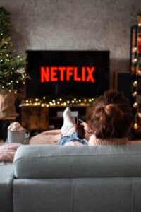 assise sur un canapé un personne regarde Netflix sur son téléviseur