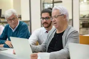 un atelier de cybersécurité pour les seniors. 3 personnes échangent sur la cybersécurité