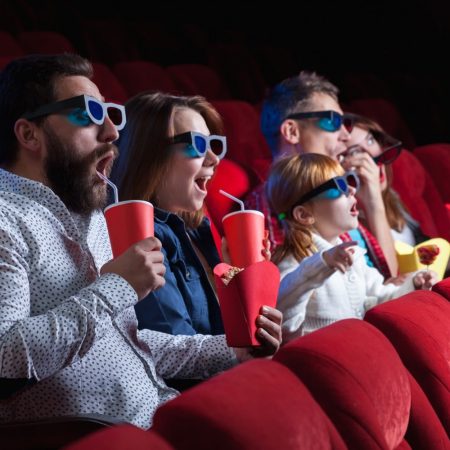 Des spectateurs assis sur les sièges rouges d'un cinéma