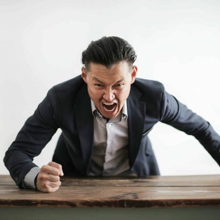 Représentation de l’attaque par force brute : un homme tape brutalement du point sur une table